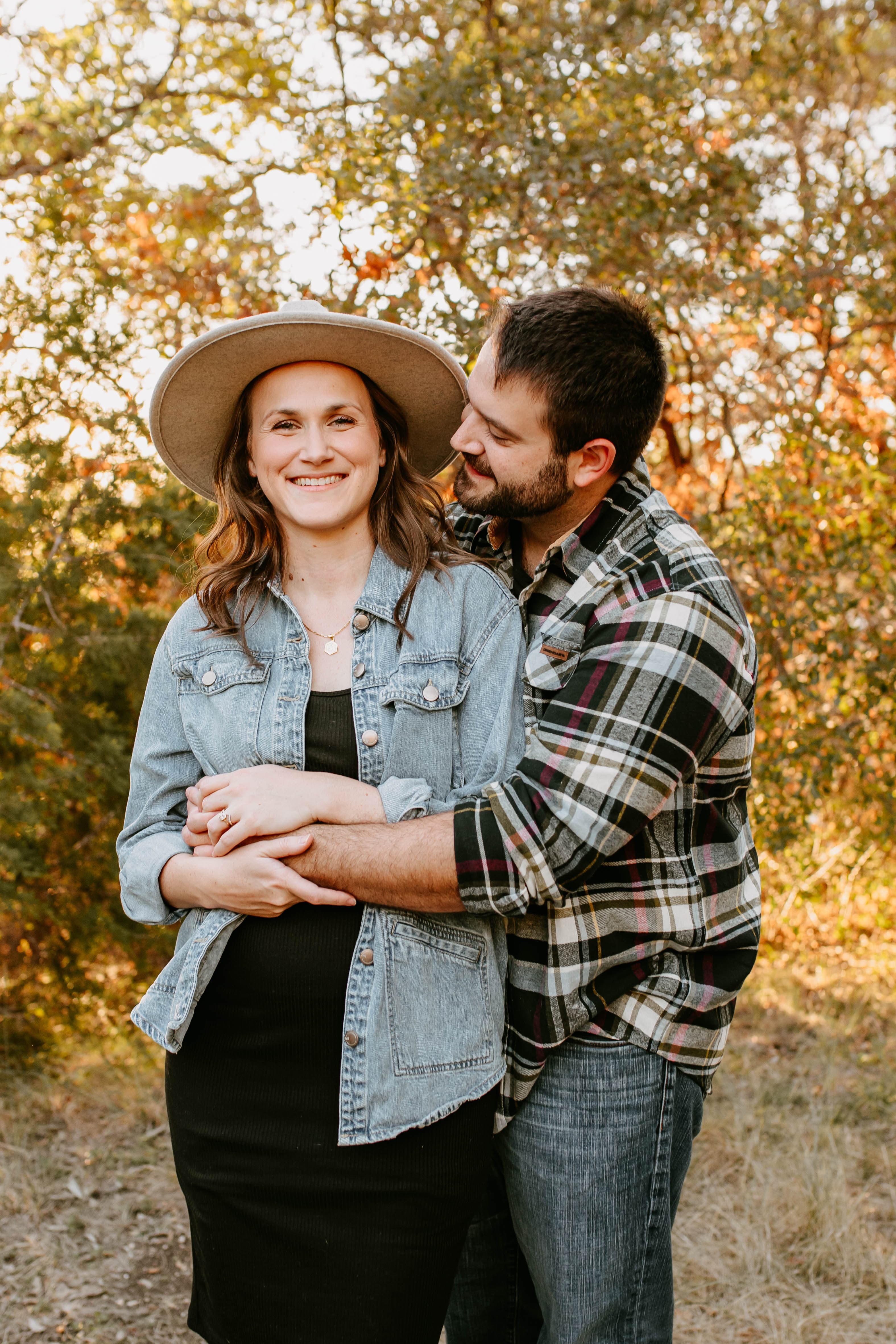 Good Soil Society's founders embracing outdoors, autumn trees behind them